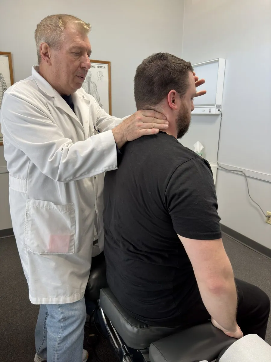 Dr. Patrick Balsier performing a cervical neck assessment on a patient at Crest Hill Clinic near Joliet, IL
