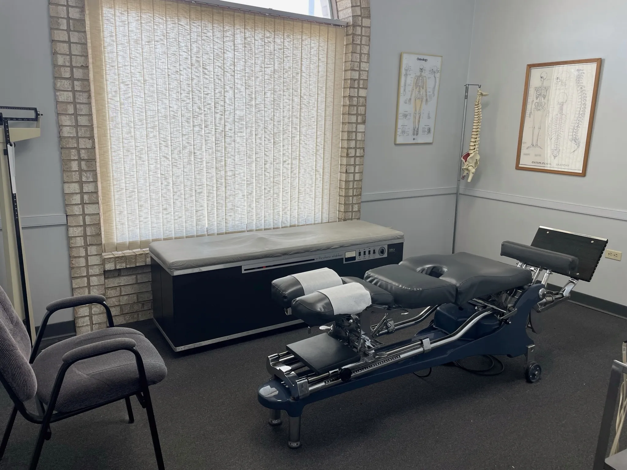 Treatment room with adjustment table and anatomy charts at Crest Hill Clinic near Joliet, IL