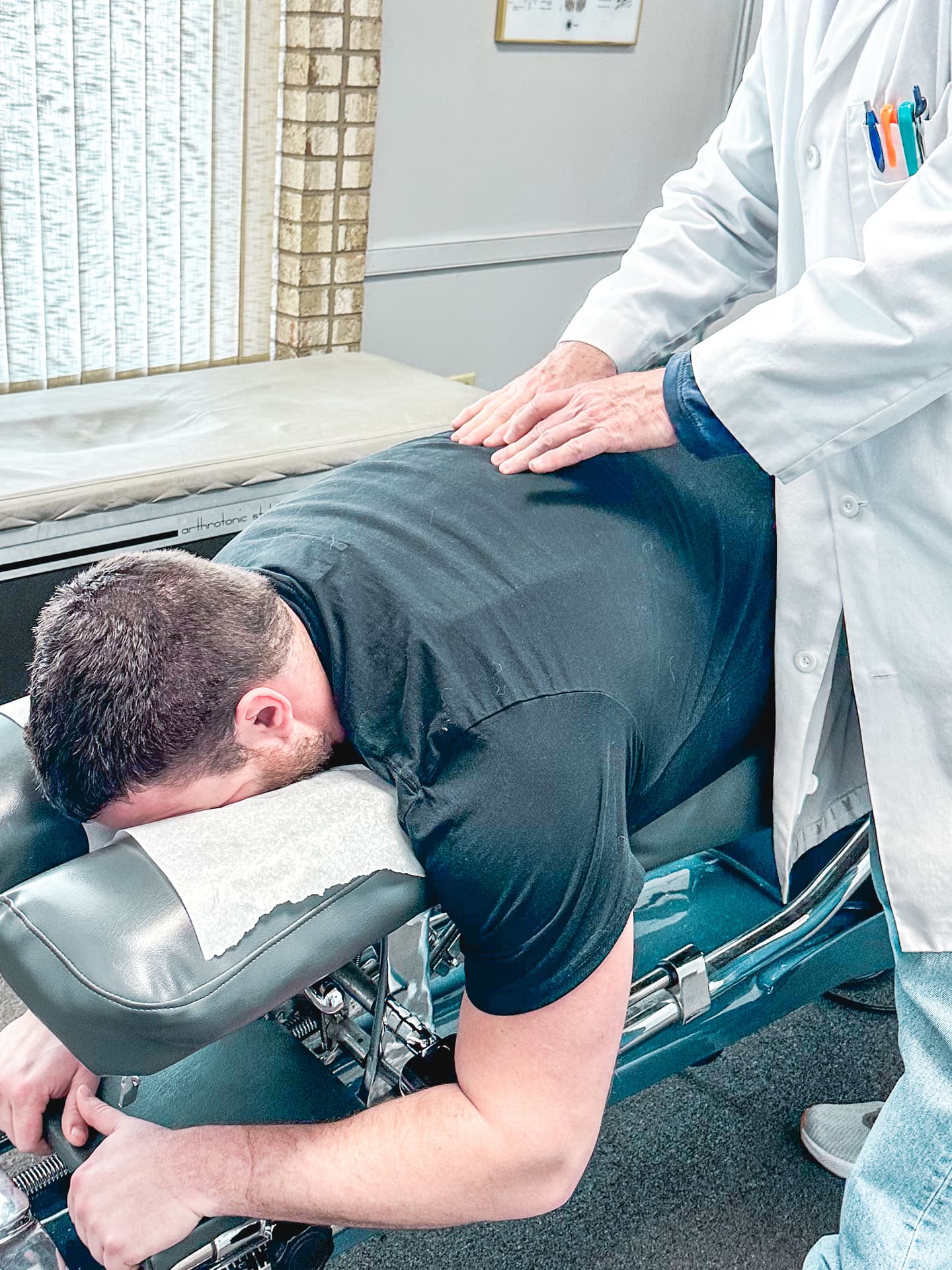 Chiropractor performing a spinal adjustment at Crest Hill Clinic near Joliet